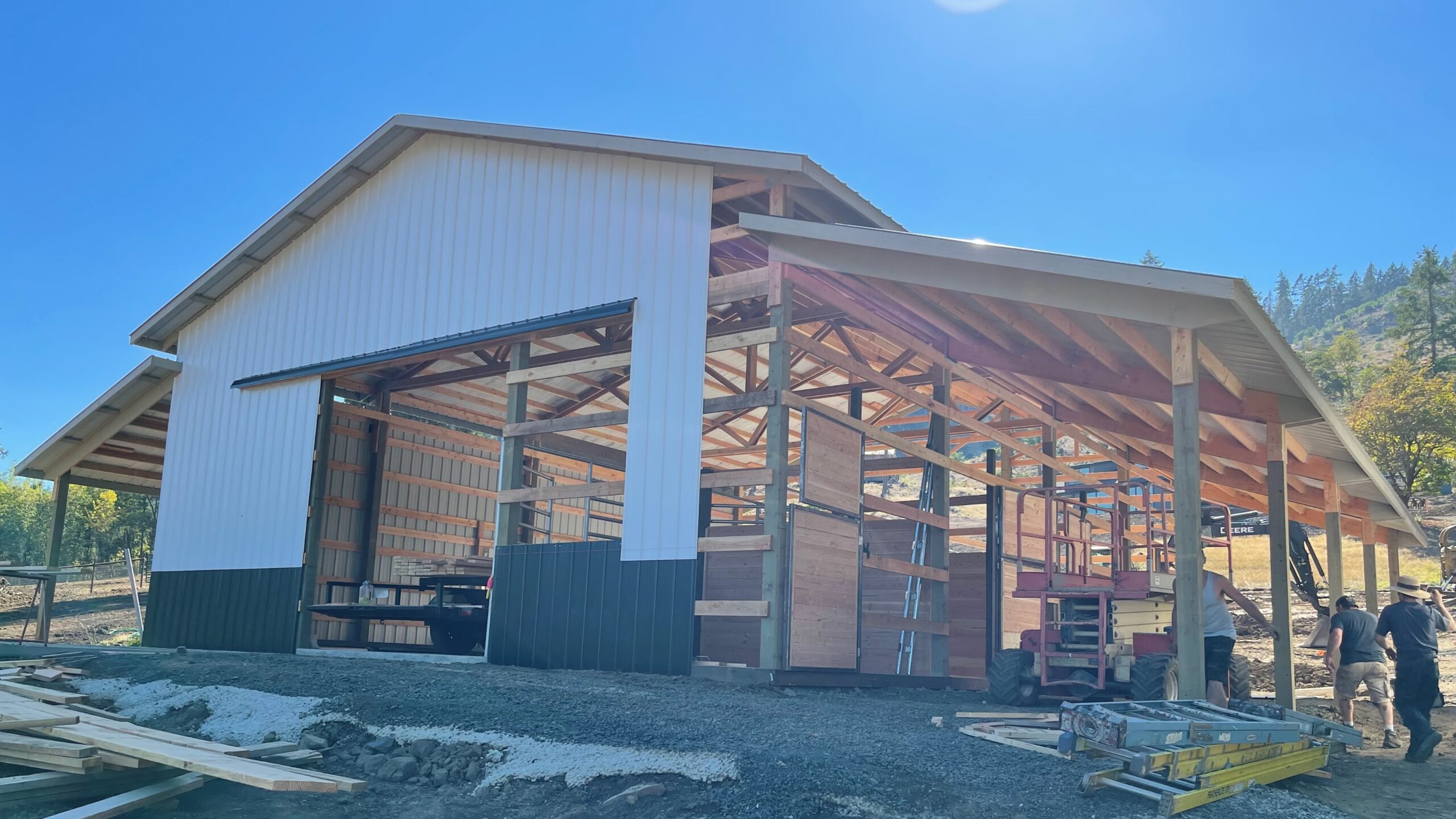 Post frame building with roof steel being installed