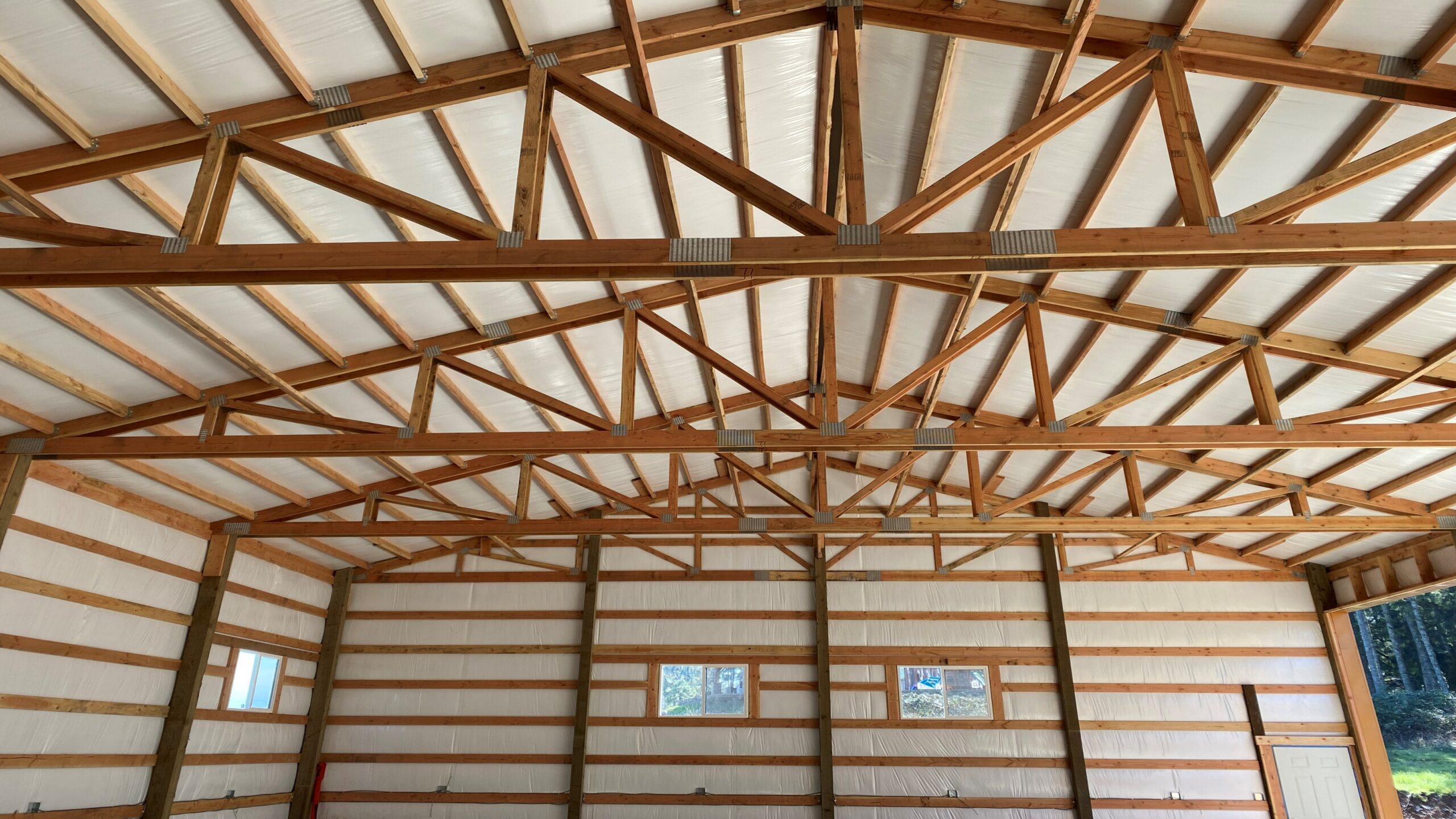 Repaired post frame interior showing trusses and purlins