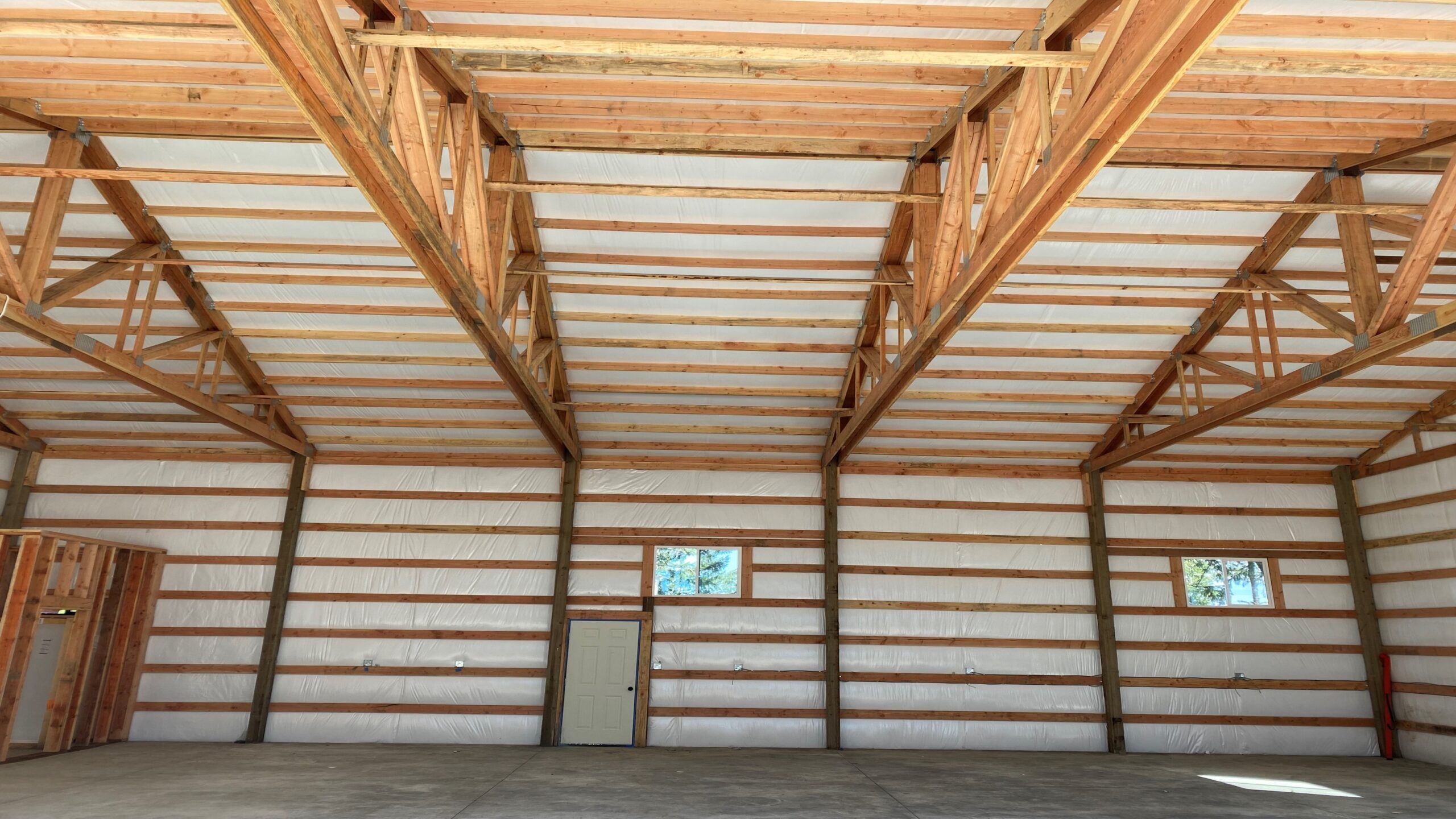 Wide interior truss span inside a post frame building