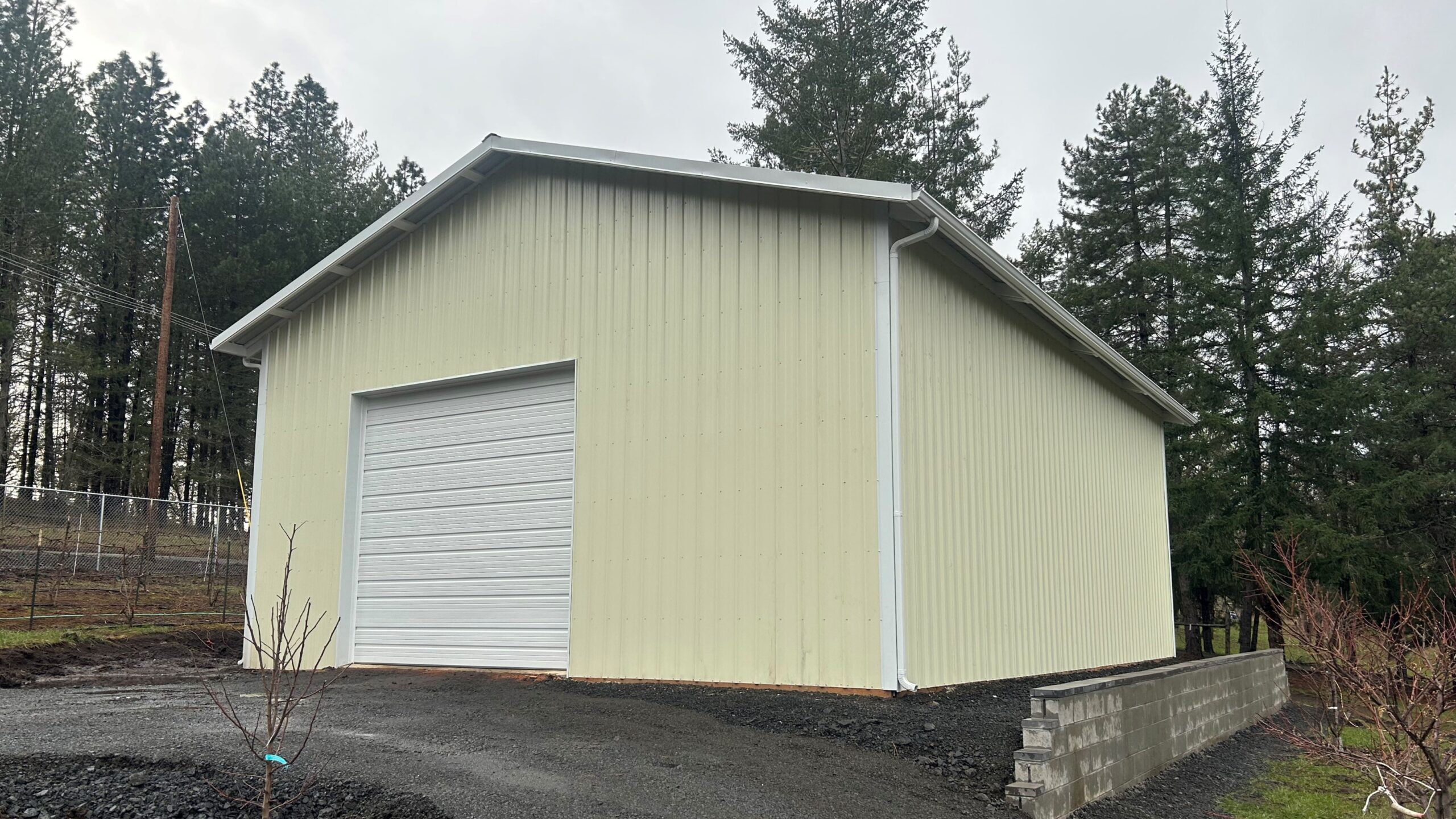 Cream post frame shop with white roll up door