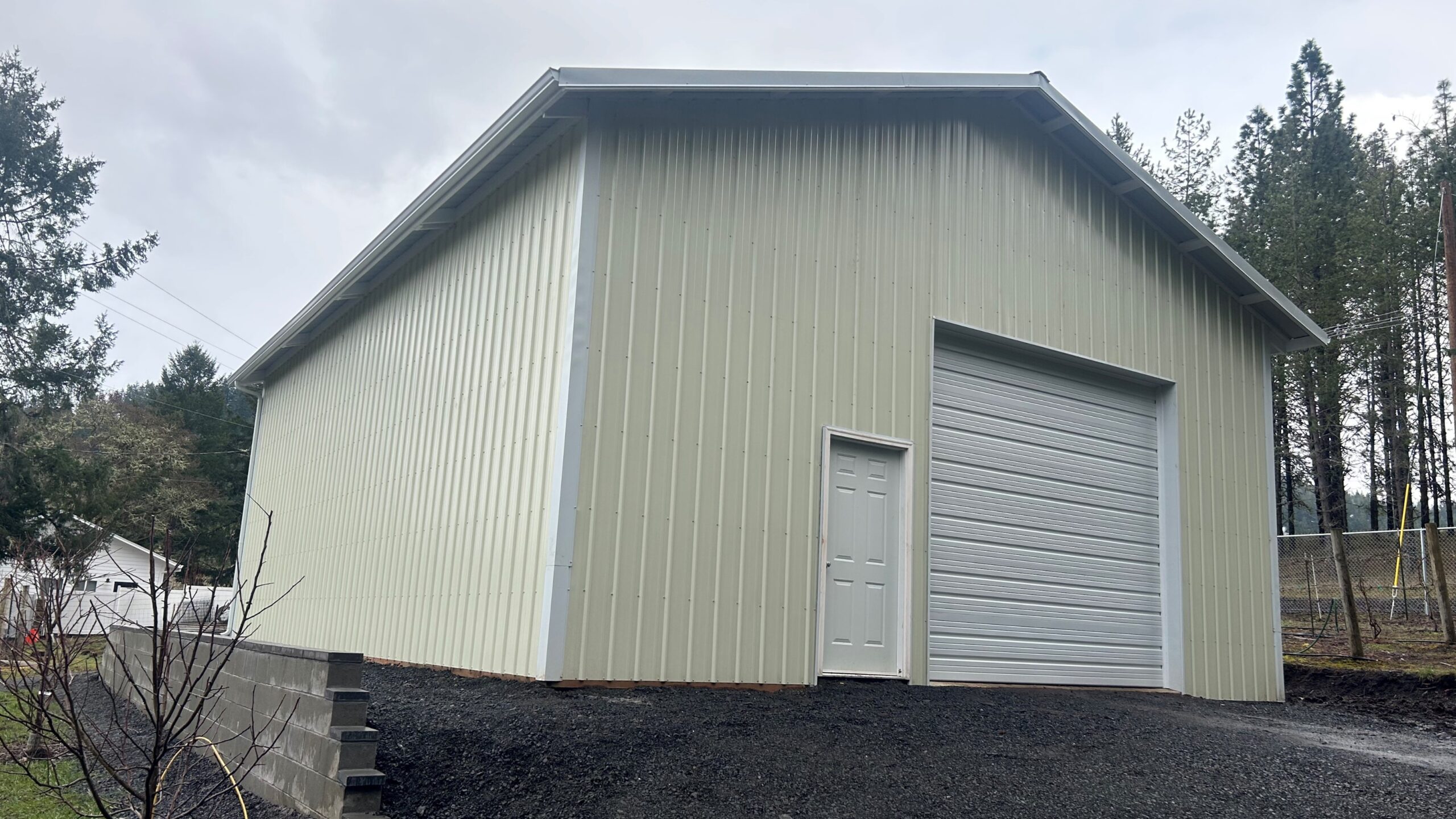 Cream post frame shop with a tall roll up door