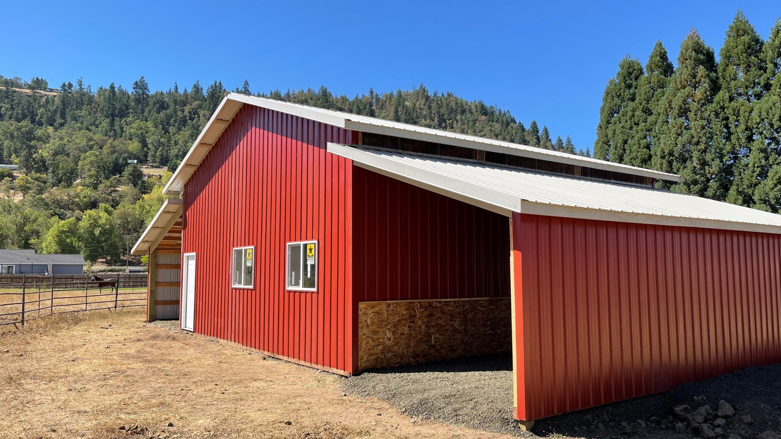 Red agricultural barn with open hay bay