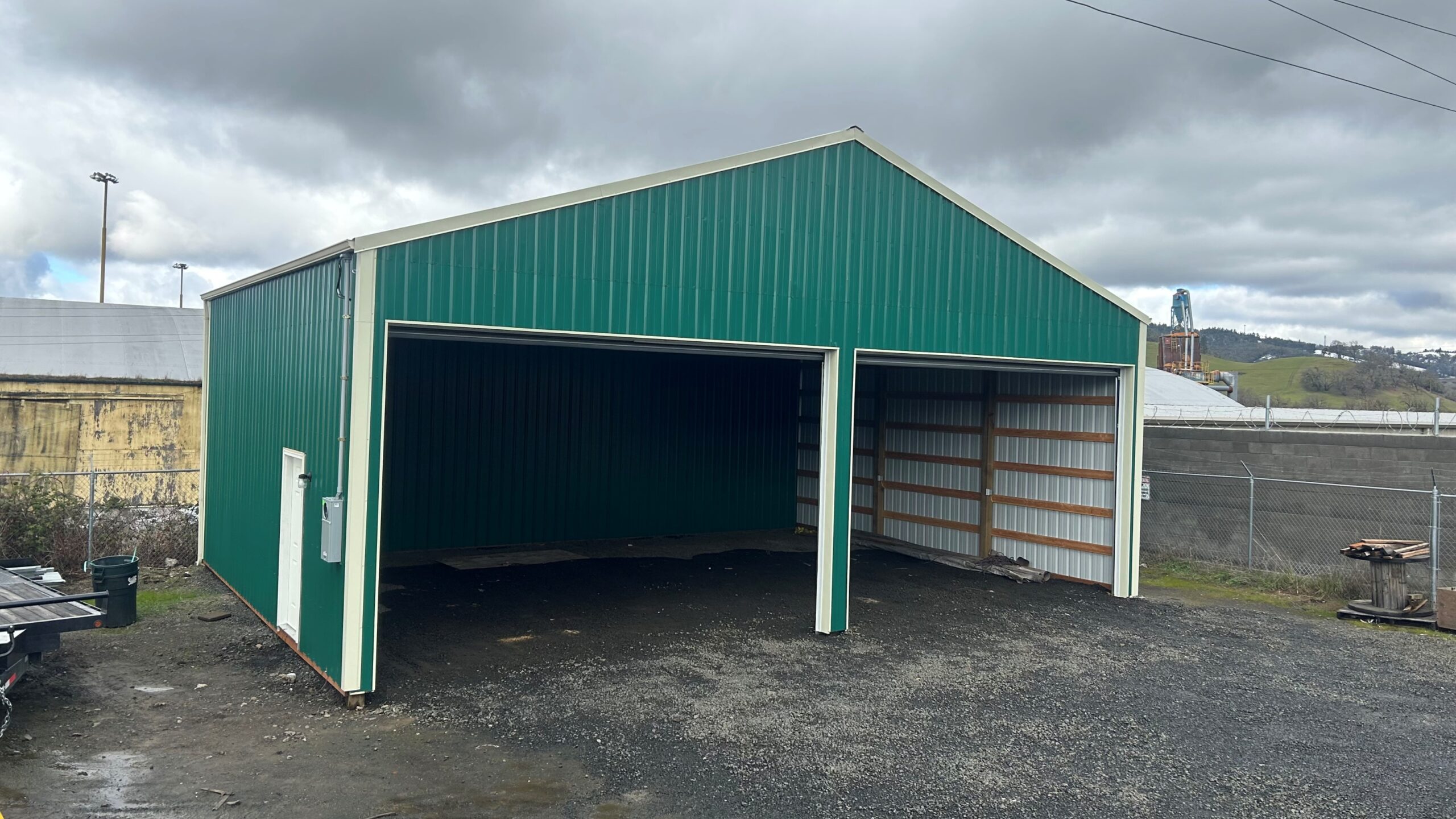 Green commercial post frame building with open bays